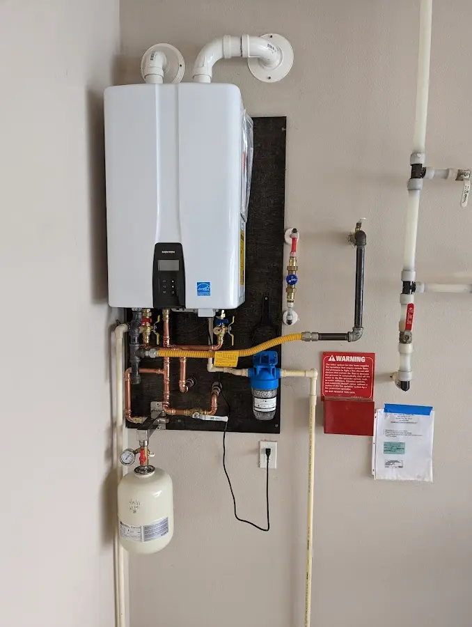 Professional plumber installing copper piping in a Milltown home